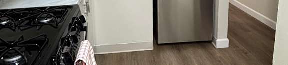 A kitchen with a black stove and white cabinets.